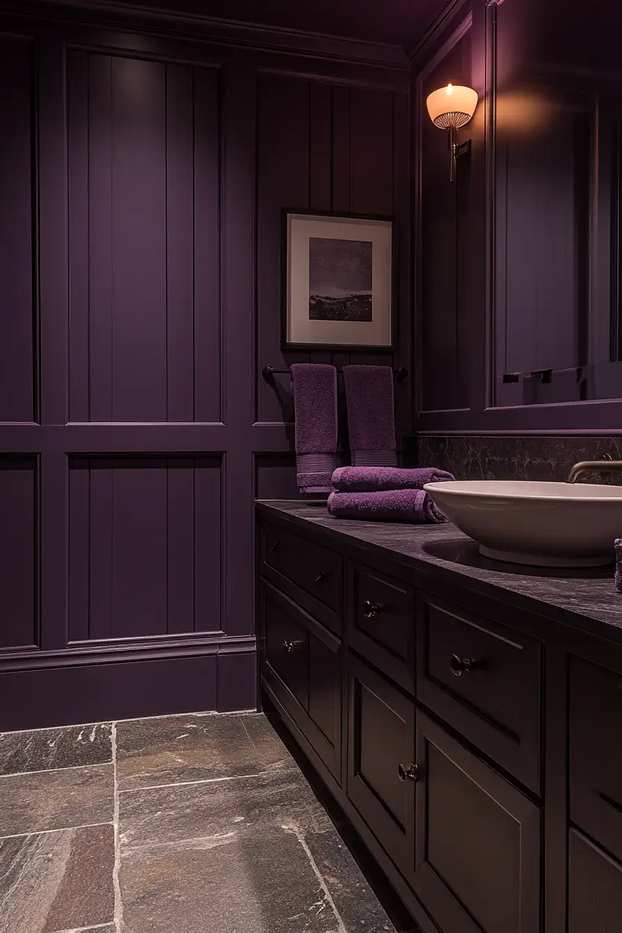 A bathroom with matte plum finishes and warm brass details