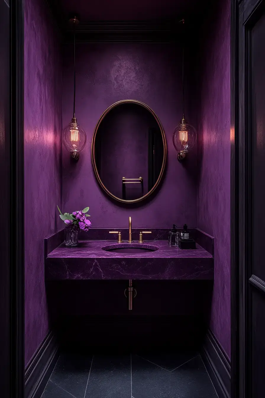 A dramatic plum powder room with a marble sink and gold mirror