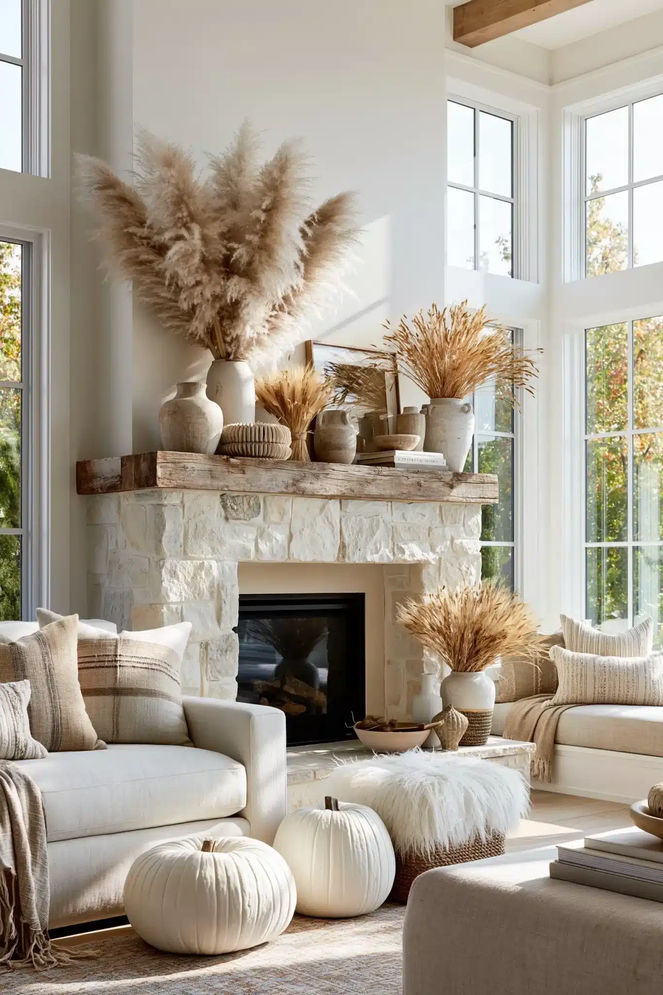 Thanksgiving mantel with pampas grass, wheat, neutral pumpkins, and wood accents.