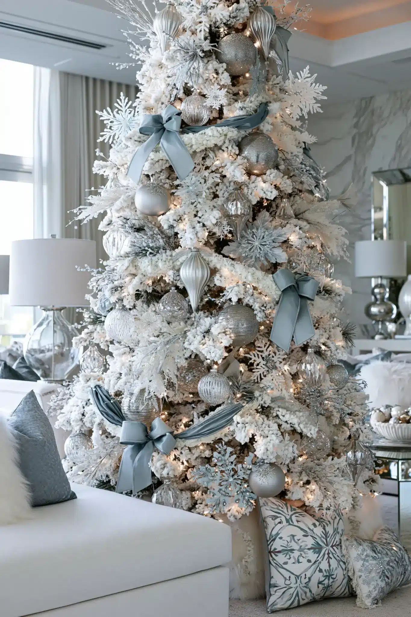 Winter wonderland Christmas tree with frosted branches, silver ornaments, and icy blue accents